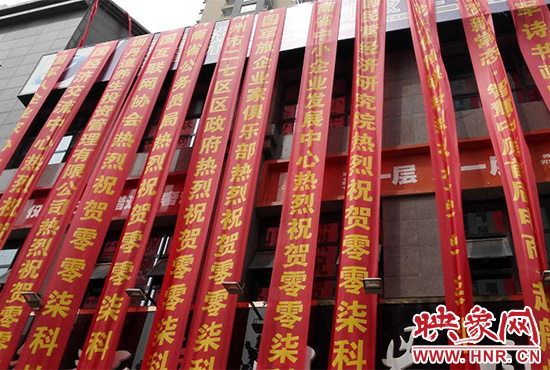 路邊一棟樓上懸掛著二三十條紅色條幅，全部是祝賀一家公司開業(yè)的。