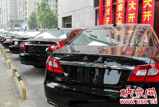 路邊一棟樓上懸掛著二三十條紅色條幅，全部是祝賀一家公司開業(yè)的。
