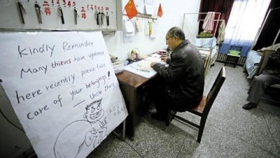 張大爺在門衛(wèi)室里工作，旁邊是紅爆網(wǎng)絡(luò)的溫馨提示牌記者