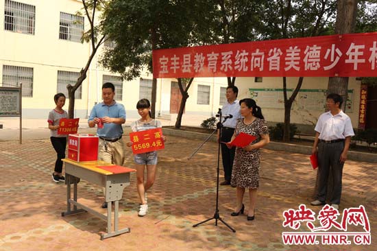 寶豐縣教育系統(tǒng)全體人員在石橋鎮(zhèn)中學(xué)為“美德少年”楊冠明同學(xué)捐款。