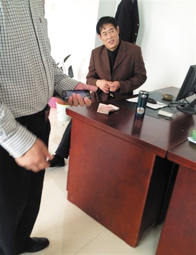 10月29日，獻(xiàn)縣國稅局稽查局辦公室內(nèi)，一名企業(yè)主交了兩萬元現(xiàn)金在桌上。新京報記者 孟祥超 攝
