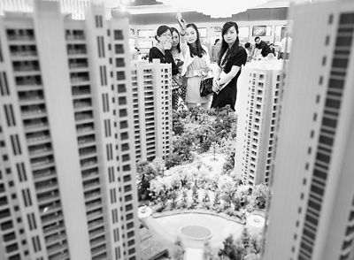 圖為近日，浙江杭州一家房產(chǎn)公司的兩位銷售人員一起向購房者介紹樓盤。新華社記者 王定昶攝