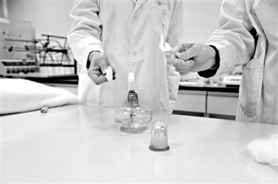 實驗人員操作的燃燒檢測法中，真蠶絲離開火焰就熄滅(左)。