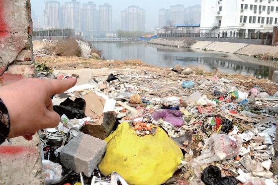 金水河長(zhǎng)江路橋下河水發(fā)臭，水邊堆放眾多垃圾