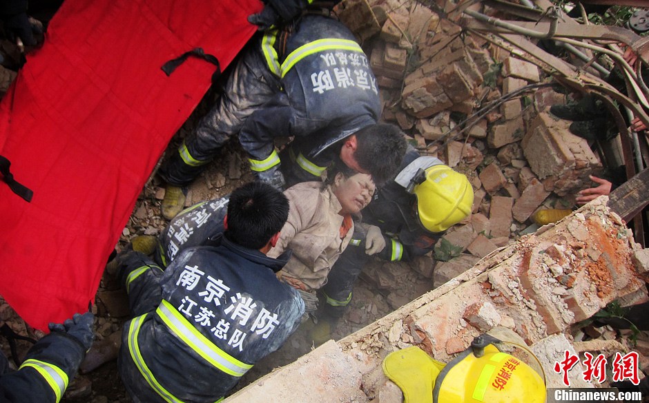 圖為南京消防隊員從廢墟中將傷者抬出。中新社發(fā) 梅亮 攝