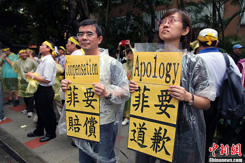 　圖為當天下午，當臺灣數(shù)百漁民在馬尼拉經(jīng)濟文化辦事處前抗議時，有兩名年輕人手持標語，在路邊聲援。中新
