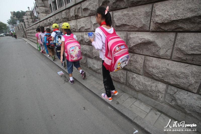 2013年09月11日，濟(jì)南運(yùn)署街上，小學(xué)生走史上“最窄人行道”上學(xué)。