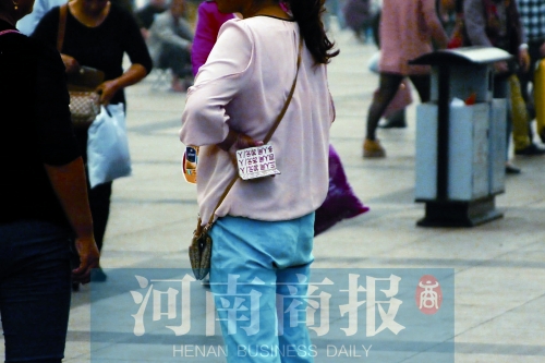 火車站廣場(chǎng)，一女子拿著寫有不同房型價(jià)位的卡片在拉客，不少市民抱怨，受過此類“騷擾”