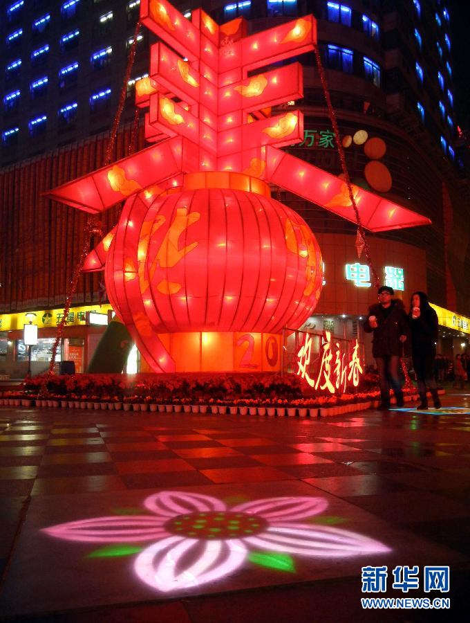 　1月30日晚，市民從蘇州市石路銀河廣場上大型“春”字彩燈景觀旁經過。