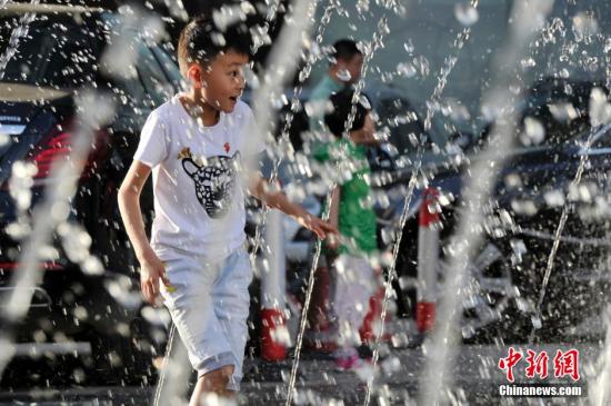 山西太原最高溫36℃,兒童在噴泉周?chē)鷳蛩睢? complete=