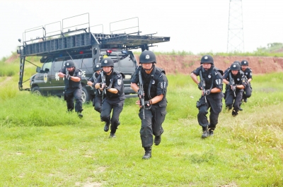 在拍攝現(xiàn)場，特警隊(duì)員下車后快速出擊。記者張琮攝影