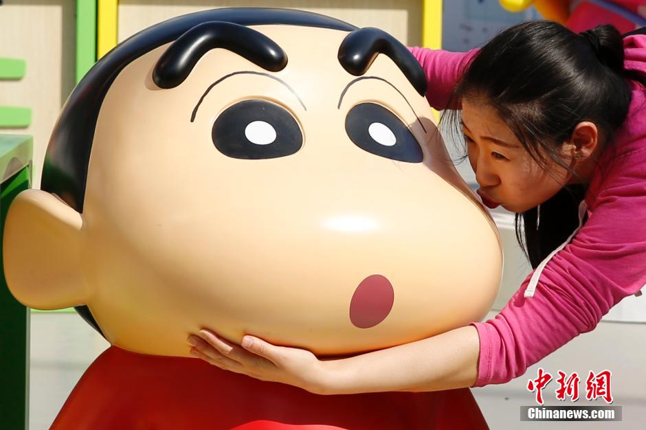 4月22日，游客與蠟筆小新合影?！跋灩P小新25周年紀(jì)念特展”日前在北京開展，吸引了不少市民游客。