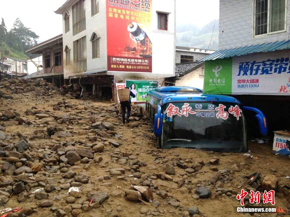 圖為山洪泥石流導沖進鄉(xiāng)鎮(zhèn)街道，導致客車被埋。