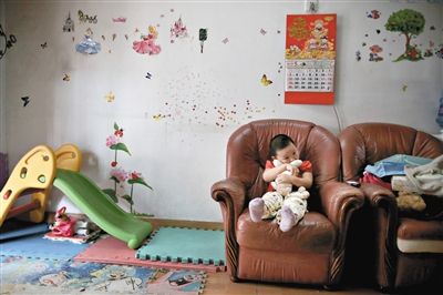 6月14日，未婚媽媽于軍的家里。女兒悅悅抱著兔子玩偶，在聽媽媽手機上的兒歌，這個4歲女孩喜歡兔子。