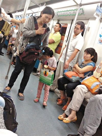 6月27日，舒馨帶一女孩在地鐵十號線行乞。她因被疑帶多個不同小孩乞討被警方搜尋。新京報記者 申志民 攝