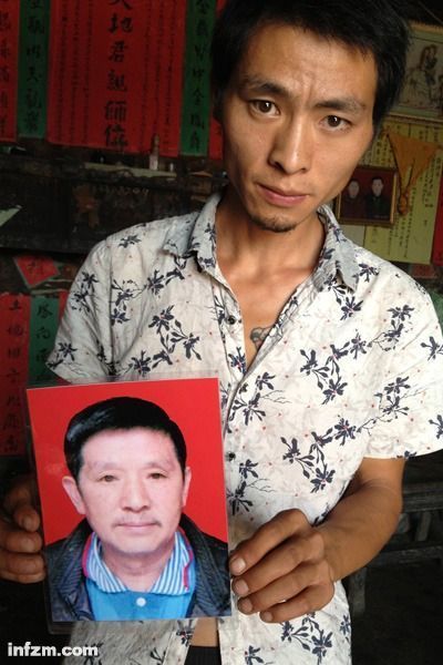 程興貴的兒子程正鵬拿著父親的遺照。程興貴自殺后，政府補償程家6000多塊錢，并終于認(rèn)定了程興貴的代課教齡。 (南方周末記者雷磊/圖)