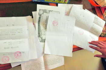 60歲的市民仇先生為了辦理公證所需的這些證明材料,半個月時間里跑了30多趟腿。記者　李萌博　攝