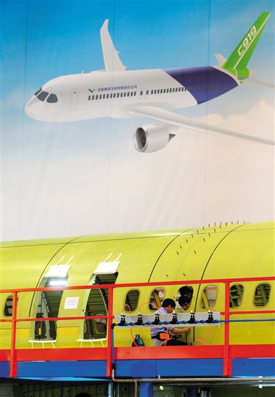 昨日，中國商飛總裝制造中心技術(shù)人員對(duì)接C919首架機(jī)的機(jī)體。新華社記者 丁汀 攝