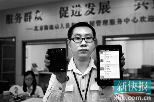 　越秀區(qū)北京街出租屋外來(lái)暫住人員管理服務(wù)中心的工作人員展示到出租屋登記來(lái)穗人員信息的儀器。