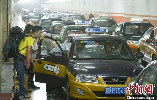 市民在北京西客站出租車候車點(diǎn)準(zhǔn)備乘車。中新社發(fā) 侯宇 攝