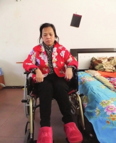 陳慶霞坐在輪椅上。她現(xiàn)在下身癱瘓，疾病纏身，生活不能自理。