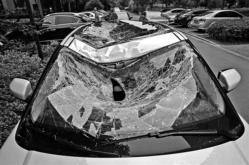 越野車車蓋以及前擋風(fēng)玻璃被砸得凹陷進(jìn)去。見習(xí)記者姚卡/攝