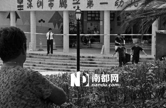 →7月19日，鵬興花園第一幼兒園門前，民警在現(xiàn)場進行完勘查取證后，園長和保安的尸體被運走。南都記者 徐文閣 攝