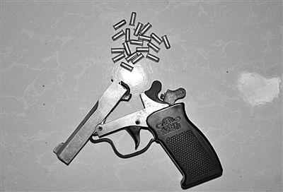 警方從搶劫嫌疑人處起獲的贓款和發(fā)令槍、子彈。警方供圖