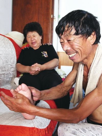 慈成富為老伴按摩。