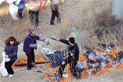 1月4日，連霍高速蘭州市榆中縣和平鎮(zhèn)段，一名警察舉著槍驅(qū)散哄搶橘子的村民。圖/CFP