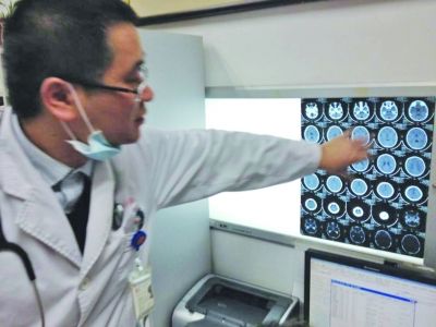 醫(yī)生在查看男孩的腦部CT片。薛馬義 攝
