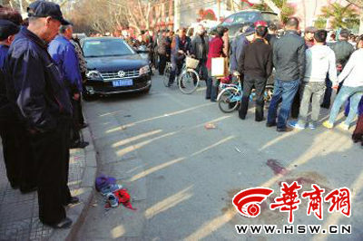 車禍現(xiàn)場的血跡被人用土覆蓋，旁邊則放著紅領(lǐng)巾、一雙童鞋和一頂帽子 本報(bào)記者 趙彬 攝