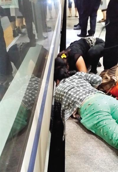 一女子趴在站臺(tái)上，救跌入列車和站臺(tái)間隙的男童。網(wǎng)友璀璨的星月夜 攝