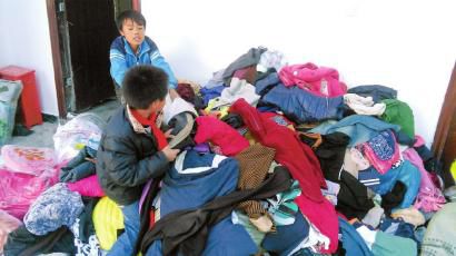 學(xué)生在幫忙整理收到的捐贈(zèng)衣服。得石中心校供圖
