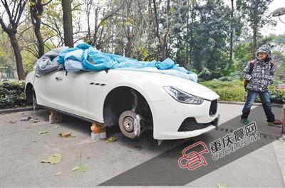 昨日，停放在重慶大學(xué)B區(qū)的一輛瑪莎拉蒂豪車被架在幾塊磚頭上，車輪不翼而飛。 重慶晨報記者 胡杰 攝
