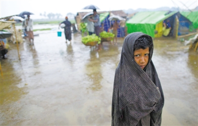 5月14日，緬甸若開邦實(shí)兌難民營(yíng)，羅興亞族難民在雨中行走。熱帶風(fēng)暴“馬哈森”即將登陸緬甸，這里的難民開始乘船撤離。