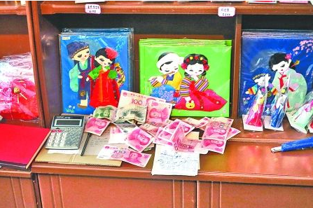 　　2012年6月21日，在朝鮮羅先特別市的一家商店里，柜臺上散落著一些人民幣。在朝鮮，人民幣比本國