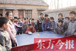 坐著輪椅的小宗成和同學(xué)們一塊打乒乓球，這是他感到最快樂(lè)的事