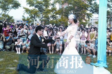在學校操場的草坪上，兩名畢業(yè)生舉行婚禮，有同學感動地抹起眼淚