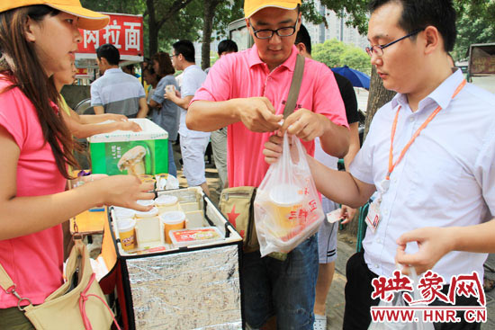 圖為徐貴雨和一名勤工助學(xué)的學(xué)生在街頭義賣快餐。
