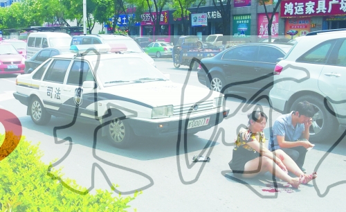 事故發(fā)生后，警車司機(jī)（右）下車查看傷者并撥打120，倆“領(lǐng)導(dǎo)”穩(wěn)坐車內(nèi)引發(fā)圍觀者不滿。