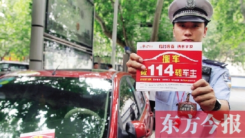 8月27日，鄭州市緯一路與經(jīng)七路交叉口，交警將“挪車請(qǐng)撥打114轉(zhuǎn)車主”的提示牌放在路邊?？康能嚿? width=