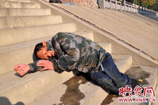 這名男子的衣服以及褲子全濕透了，水從衣褲里流出來，嘴里散發(fā)著濃烈的酒氣。