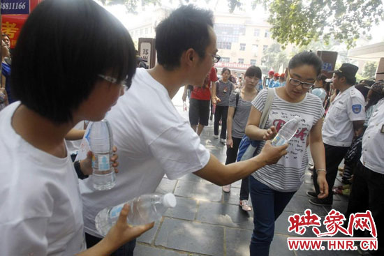 志愿者為剛剛考試完的考生送上1瓶冰凍的冰露·純悅，消暑解渴為考生加油