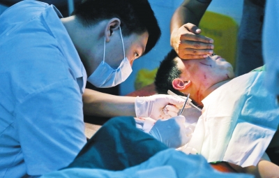 孩子身上有7道傷痕，其中兩道需要縫合，其他的均為擦傷，醫(yī)生正對(duì)他施治。