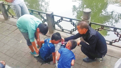 男孩被救出后，圍觀群眾幫他控水換衣服。