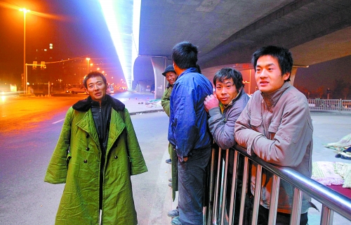 冬夜里，農(nóng)民工在橋下等著干活兒。