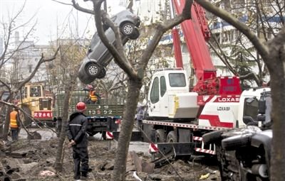 輸油管道爆炸后，搶修人員將被炸毀的車輛運(yùn)出現(xiàn)場(chǎng)。