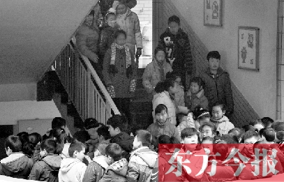 　某小學(xué)的學(xué)生走下樓梯放學(xué)。