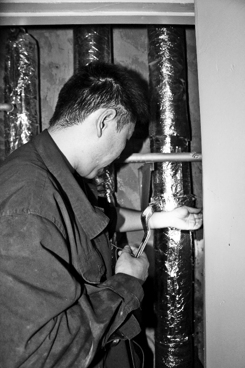 苗師傅一邊進(jìn)行維修，一邊用耳機(jī)接聽市民的電話。